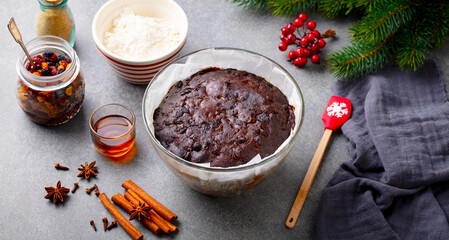 Christmas pudding in glass baking dish. Traditional festive dessert. Grey background. Close up.