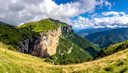 Scenic mountain landscape with grassy slopes, cliff face, distant mountains, and vibrant sky filled with puffy clouds