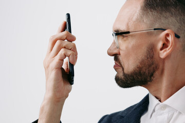 A business professional man on an isolated colored background, expressing thoughtful concentration while speaking on a mobile device, conveying focus and purpose.