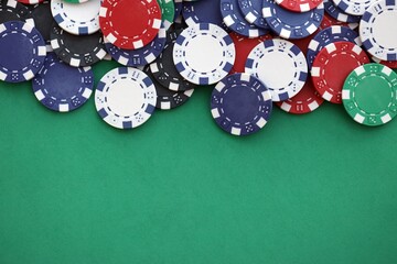 Casino gaming background with stacks of betting chips of different colors on green gaming mat