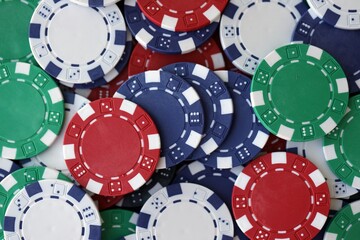 Close up of a group of casino chips on a green mat for poker or dice games indoors