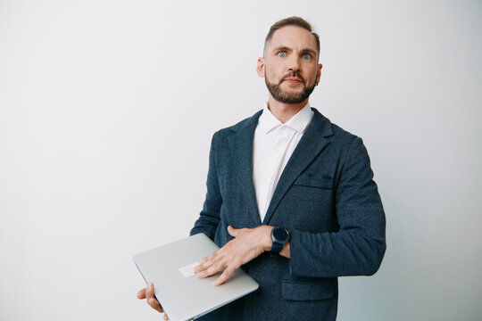 A professional businessman stands against an isolated colored background, holding a laptop with calm confidence. His poised posture suggests readiness for strategy, meetings, and leadership tasks.