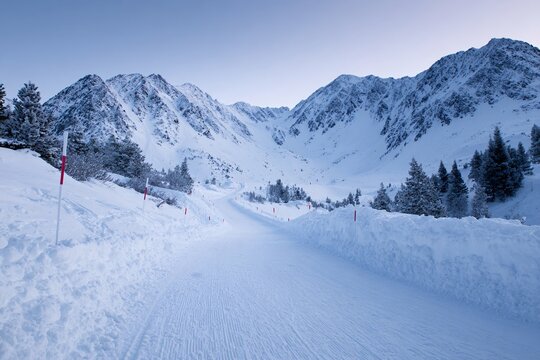 Wide-angle view of a snowy biathlon competition trail in the mountains