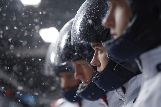 Team preparing for bobsleigh run during snowy weather