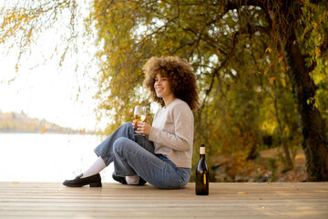 Enjoying a sunny afternoon by the water with a glass of wine and a gentle breeze