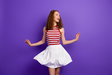 Naklejka premium Young woman in striped singlet and white skirt spins with joy against purple background fashion model style and summer vibe
