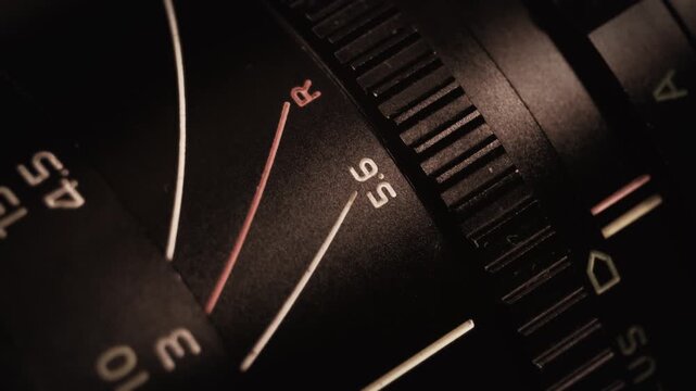 Camera lens aperture and focus ring adjusting the photoshoot. A macro video shot, showing the details of a vintage manual lens with number meters and text