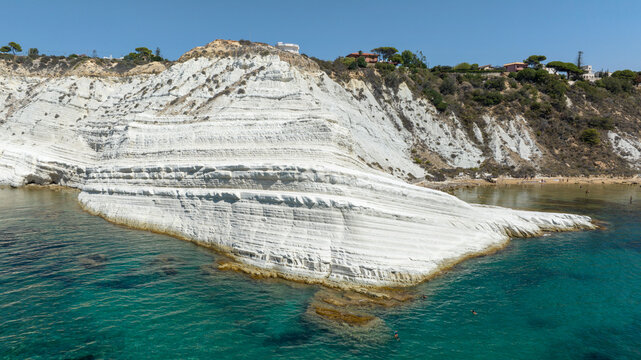 Aerial view of the Scala dei Turchi (Stair of the Turks or Turkish Steps) on the coast of Realmonte, near Agrigento, Sicily, Italy. It's a rocky cliff and tourist attraction. The sea is turquoise.