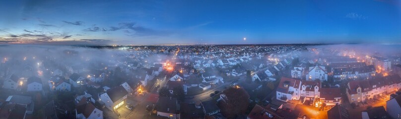 Evening aerial panorama of Moerfelden Walldorf with fog and Frankfurt skyline