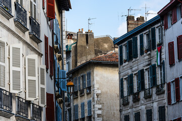 Fototapeta premium Charming white buildings with green shutters in the heart of Bayonne, France.