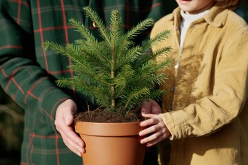 Eco family planting small Christmas tree together. Sustainability lifestyle.