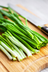 Fresh green onions on a wooden cutting board, kitchen still life