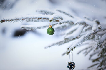 Snow covered fir branches with Christmas decorations on winter outdoor