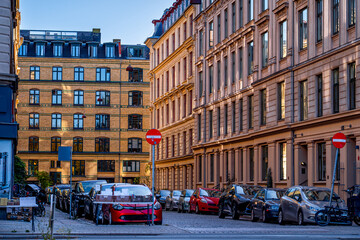 Obraz premium Street in the Østerbro district of Copenhagen with colorful traditional residential buildings and parked cars. 
