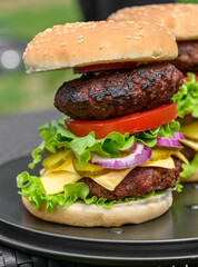 Side view of a double beef burger with tomato and lettuce, burger template from the side