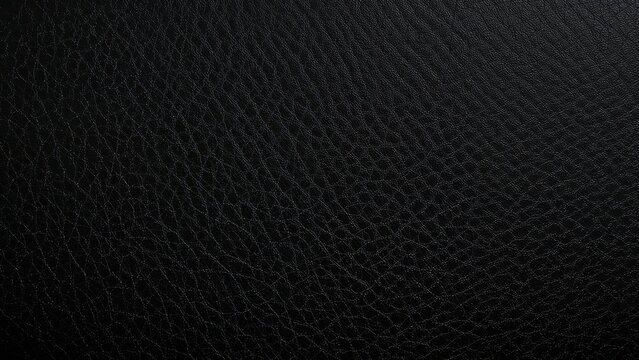 Pattern of black leather texture with fine grain and stitching. Close-up of synthetic or genuine leather surface.
