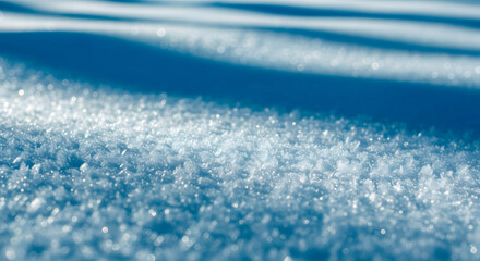 Closeup of sparkling snow crystals with soft blue shadows, abstract winter texture