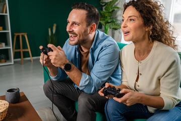 Happy couple enjoying leisure time playing video game