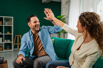 Happy couple playing video games and high five