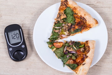 Glucose meter for sugar level control and piece of vegetarian pizza. Nutrition and eating fast food during diabetes