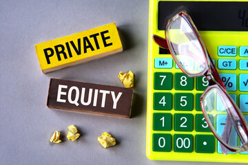PRIVATE EQUITY - words on wooden blocks with calculator and glasses in the background