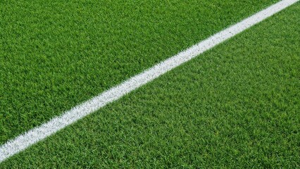 Obraz premium A close-up of a soccer field with a white line dividing the green grass.