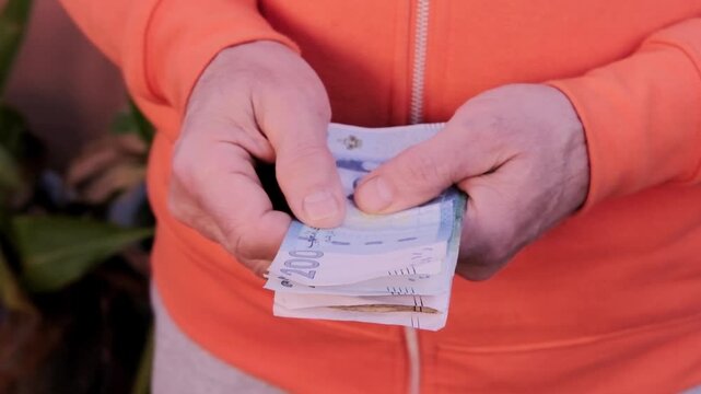 closeup male hands hold Moroccan dirham money, count paper dirham banknotes, concept cash payments, monetary savings, save for vacation, exchange and cashing currency