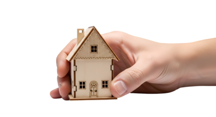 hand gently holding a small wooden house model, isolated on white background