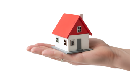 hand holding a small red-roofed house model on white background