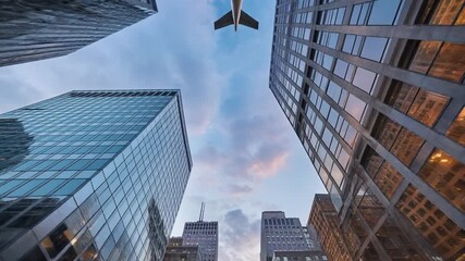 Looking up at modern skyscrapers and a plane flying in the sky, showcasing urban architecture and travel - Powered by Adobe