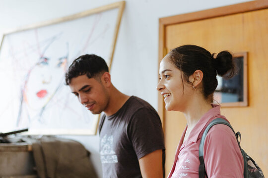 Art students smiling and interacting in a classroom setting, learning and enjoying their creative studies