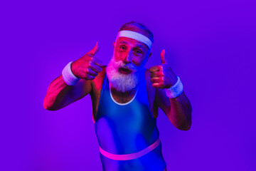 Elderly man in retro blue jumpsuit gives thumbs up under purple neon lights for fitness wellness lifestyle advertising