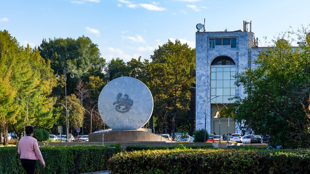 Monument to Bishkek Batyr stands prominently in Ala-Too Square, surrounded by lush greenery and modern architecture, symbolizing Kyrgyz heritage and pride