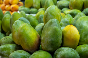 Tropical mango fruit at farmers market. Fresh mangoes displayed on market stall. Ripe mangoes for sale at local bazaar.