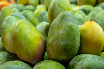 Tropical mango fruit at farmers market. Fresh mangoes displayed on market stall. Ripe mangoes for sale at local bazaar.