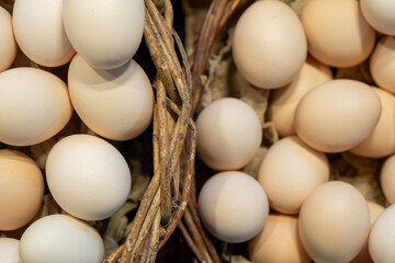 Brown and white eggs arranged on market counter. Local farm fresh eggs sold at outdoor market. Organic farm eggs for sale at farmers market.