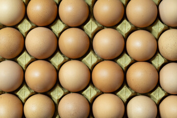 Brown and white eggs arranged on market counter. Local farm fresh eggs sold at outdoor market. Organic farm eggs for sale at farmers market.
