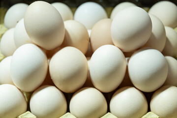 Brown and white eggs arranged on market counter. Local farm fresh eggs sold at outdoor market. Organic farm eggs for sale at farmers market.
