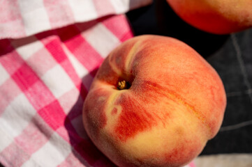 Fresh, juicy peaches arranged on a kitchen table. Natural summer fruit with vibrant colors, ready to eat or use in cooking and desserts.