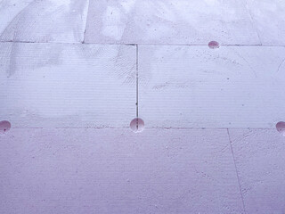 Insulation boards of extruded polystyrene foam (XPS) with anchor holes, showing thermal facade installation and construction texture for energy efficiency and modern architecture.