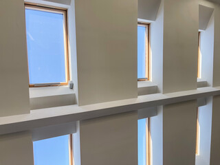 Multiple skylight windows installed in a contemporary sloped ceiling, showcasing modern interior architecture, natural light design, and bright attic space for residential and commercial concepts
