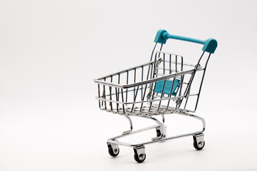 E-commerce Potential: Empty Miniature Metal Shopping Cart with Teal Handle on a Crisp White Background