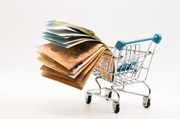 Dynamic Cash Flow: Multiple Fanned Euro Banknotes Displayed in a Tiny Shopping Cart, Symbolizing Market Movement