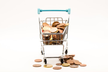Vertical Abundance: Small Shopping Trolley Overflowing with Euro Coins, With More Scattered on the Ground