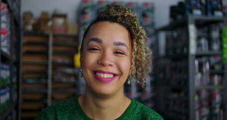 Close-up of smiling female entrepreneur in a hardware store, exuding confidence and positivity, with shelves of paint and supplies in the background