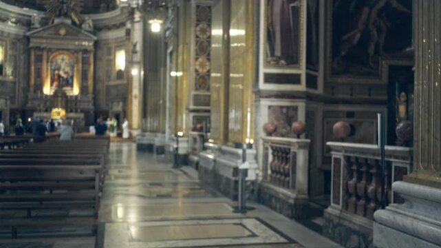 Blurred soft bokeh view of ornate catholic nave and marble aisle in shallow focus church; backdrop copyspace overlay calm.