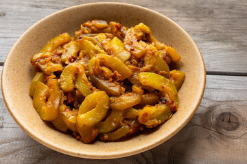 A bowl with homemade Pakistani-style zucchini curry with ginger, garlic, tomato, onion, and spices.
