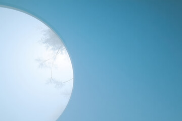 minimalist composition of delicate snowflakes enclosed in circle against clean blue sky