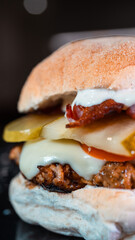 Juicy burger with special rub, melted cheese, onion chutney, crispy bacon, gherkins, and tomato slices. Perfect comfort food for gourmet meals and promotions.