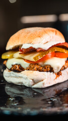 Juicy burger with special rub, melted cheese, onion chutney, crispy bacon, gherkins, and tomato slices. Perfect comfort food for gourmet meals and promotions.
